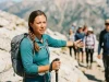 How to Master Group Hiking Leadership Without Being a Jerk Female hike leader looking back with trekking pole on rocky trail
