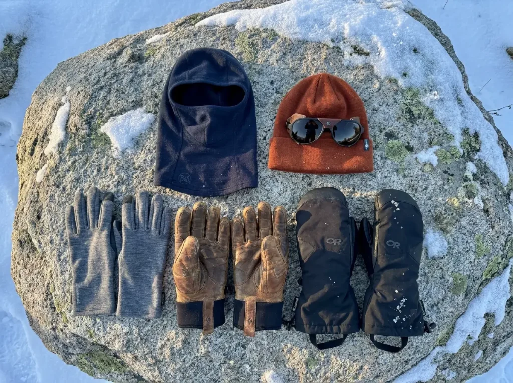 Close-up of layered mitten system with liner gloves and shell mitts in snow
