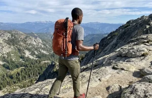 4 Times One Trekking Pole Beats a Pair on Trail Hiker using a single trekking pole on a rocky alpine trail with mountain views