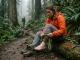 Your Sock Rotation Is Wrong and Blisters Prove It Female hiker resting on a switchback changing a wet Darn Tough sock to manage her sock rotation strategy.