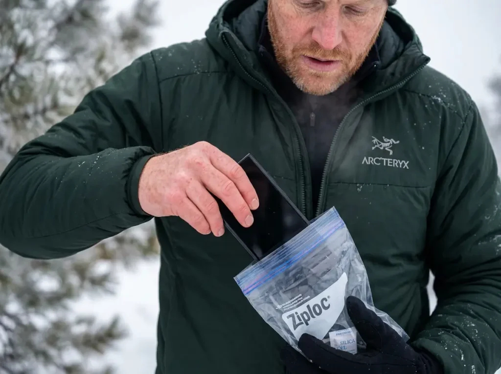 Hiker trail-proofing a phone by putting it in a Ziploc bag