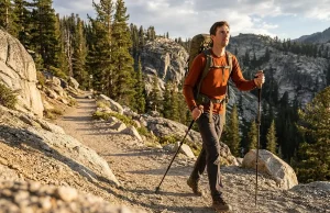 Best Trekking Poles for Hikers Over 6 Feet Tall Tall hiker on ascending trail using extended trekking poles at correct 90-degree elbow angle.