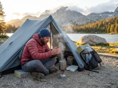 What Thru-Hikers Pick for One-Person Ultralight Tents Solo backpacker boiling water beside a pitched one-person ultralight tent at alpine dawn beside a mountain lake