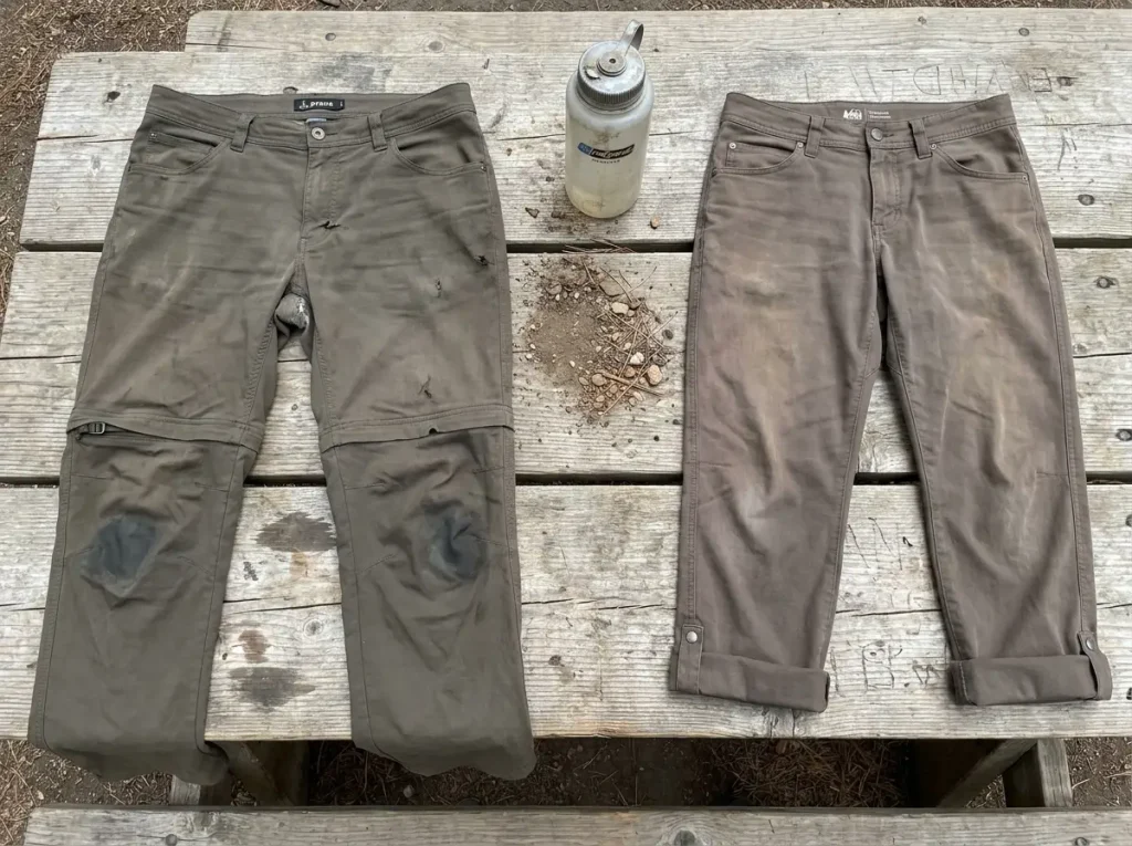 Worn zip off hiking pants showing knee area fabric degradation and zipper wear