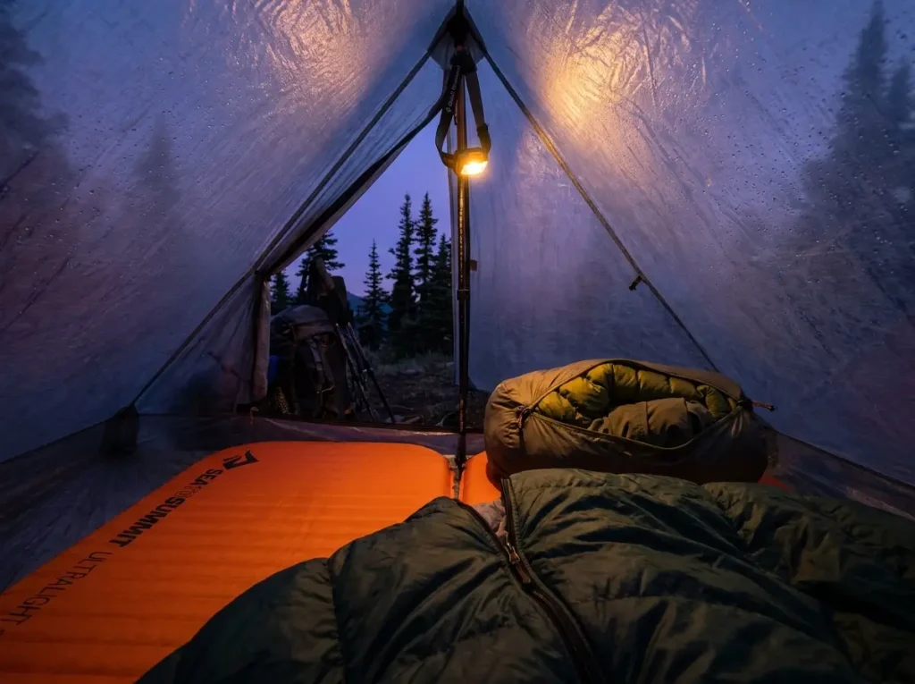 Detached zip off pant legs stuffed as pillow inside hiking tent