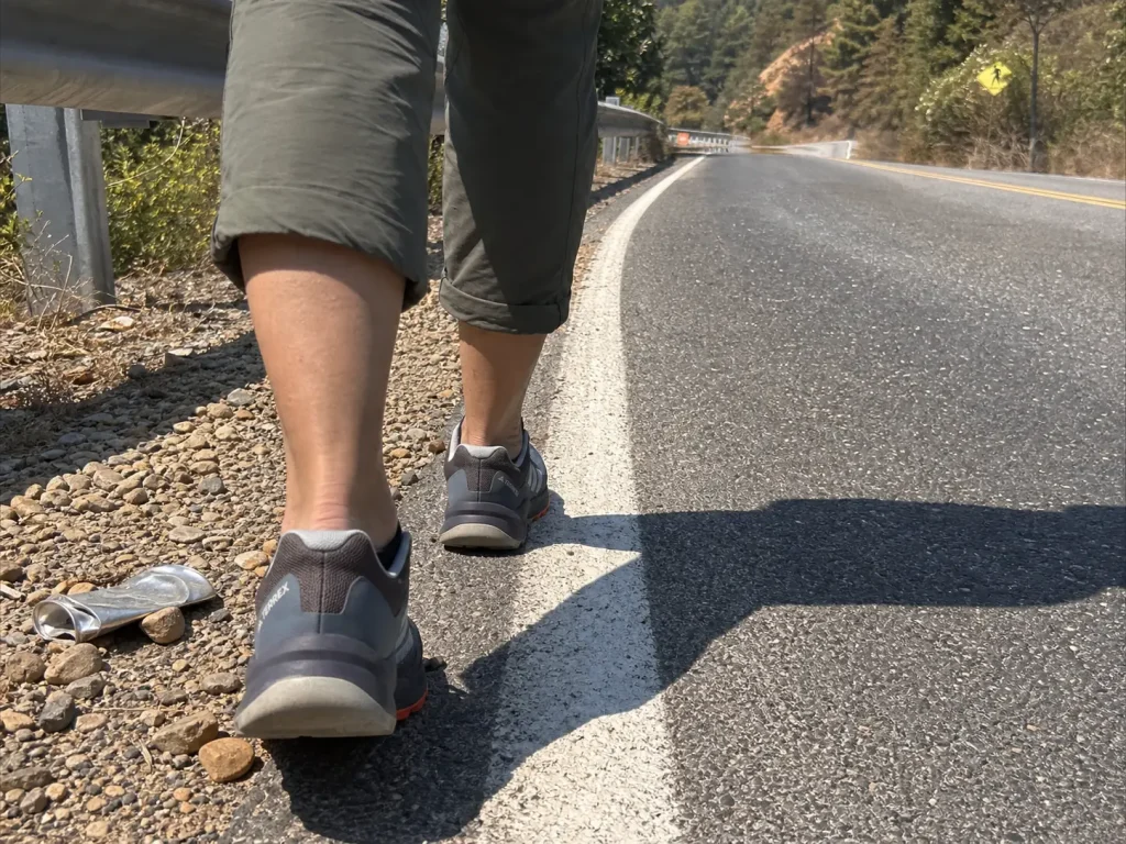 Hiker walking a paved rail-trail roadwalk section in road-to-trail hiking shoes