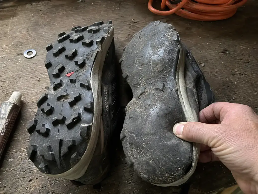Worn trail runner outsole with flattened lugs beside a fresh pair for comparison