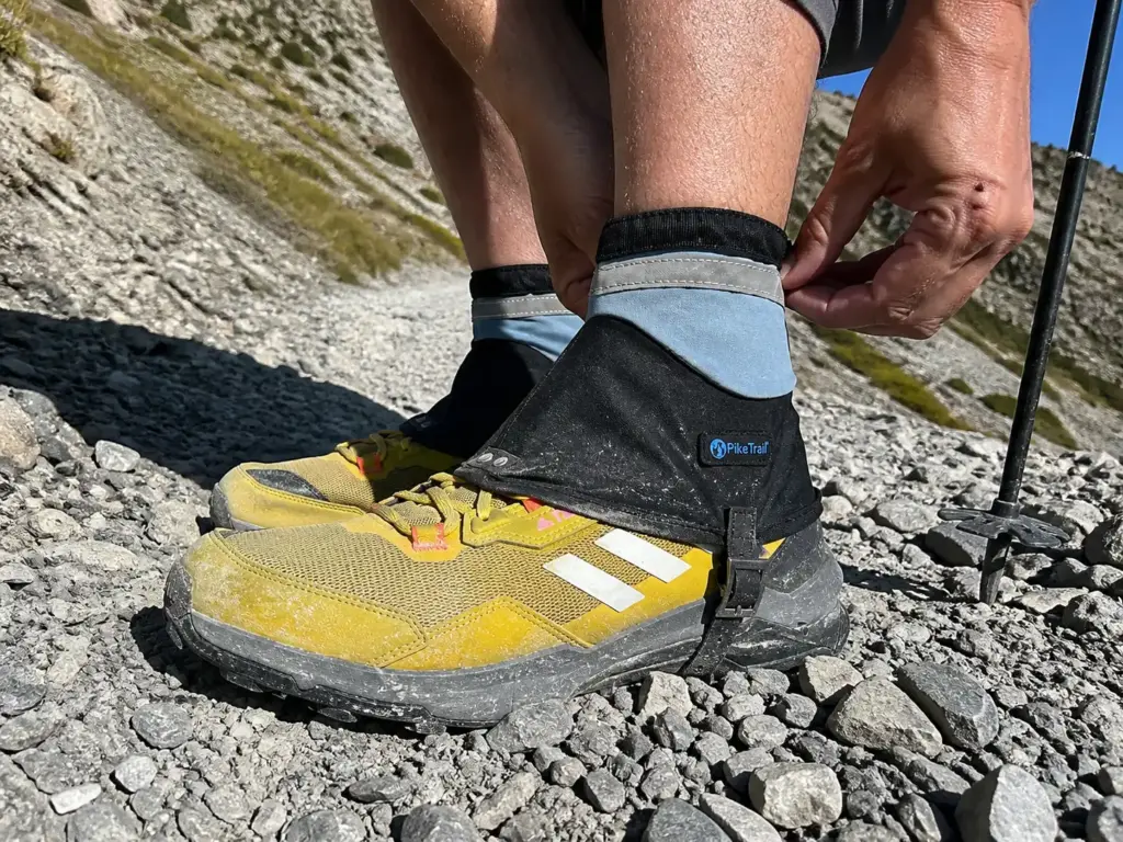 Low ankle gaiters over trail shoes blocking scree debris on a fast hike