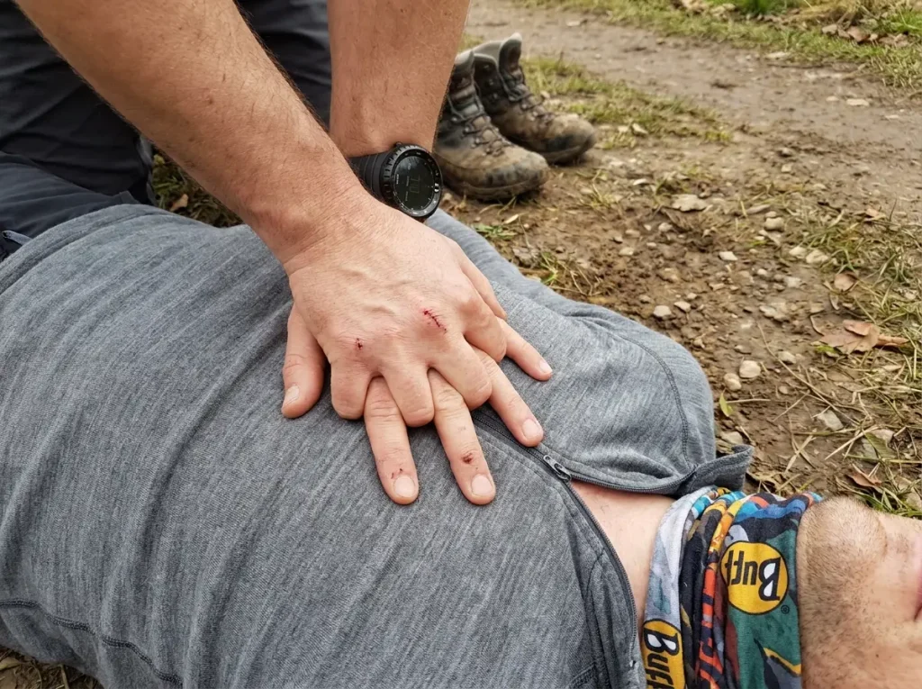 Close-up of proper hand position for CPR chest compressions on uneven ground