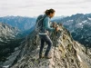 5 Ridge Hiking Mistakes That Make Heights Worse Hiker pausing on narrow exposed mountain ridge with trekking poles