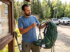 I Filed 11 Gear Warranty Claims. Here’s What Works Hiker examining a broken backpack strap with warranty tag visible