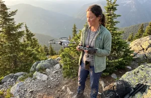 Drone Use on Hiking Trails Rules Every Flyer Misses Hiker launching a small drone from a mountain trail clearing at golden hour