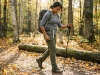 After 500 Miles I Know Which Pockets Work on Trail Hiker reaching into hiking pants thigh pocket while walking on a forest trail