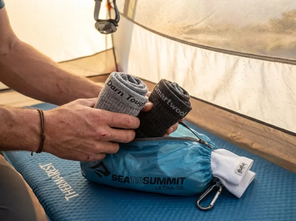 Close-up of two pairs of merino wool hiking socks packed inside a stuff sack