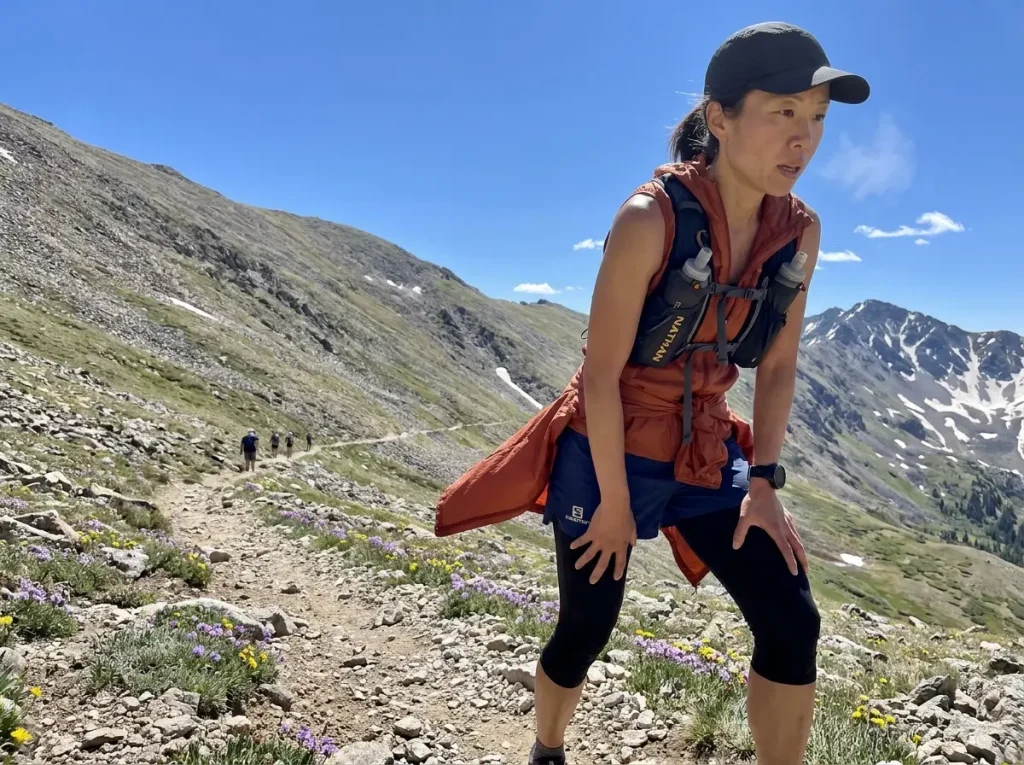 Trail runner power hiking steep uphill on mountain switchback