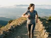 Running Vest vs Daypack and What Your Pace Decides Fast hiker in a Salomon running vest reaching for a front soft flask at dawn on a ridge trail
