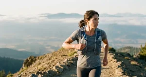 Running Vest vs Daypack and What Your Pace Decides Fast hiker in a Salomon running vest reaching for a front soft flask at dawn on a ridge trail