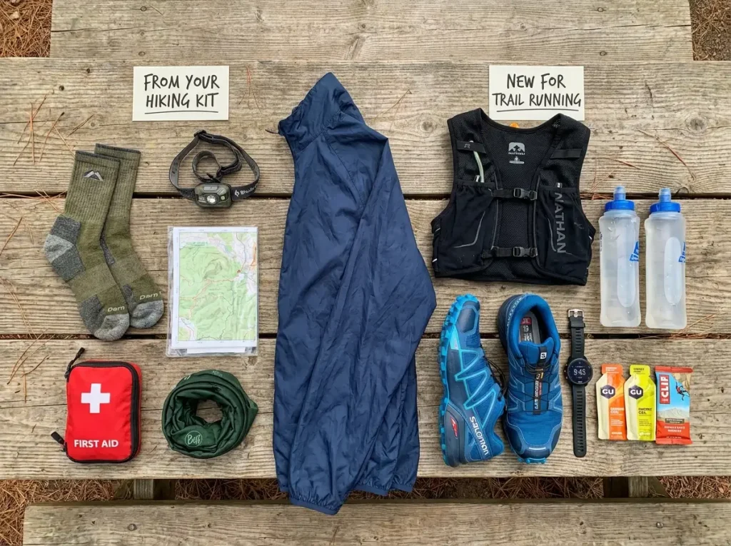 Trail running gear laid flat on wooden surface with hiking gear for comparison