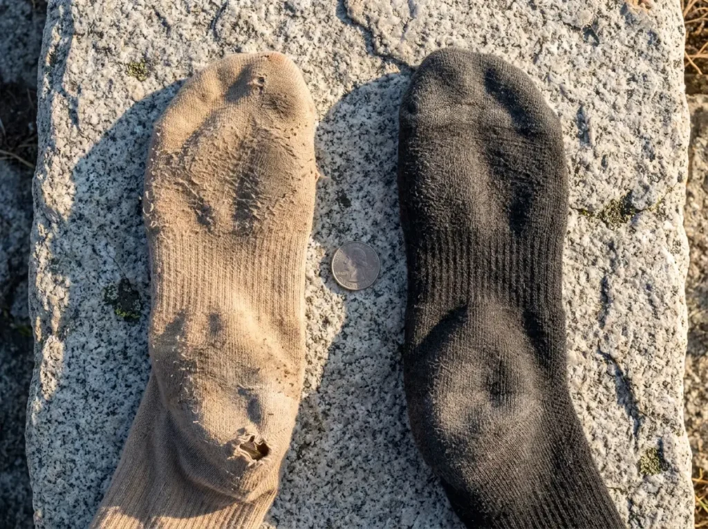 Side-by-side comparison of worn bamboo and merino socks after months of hiking