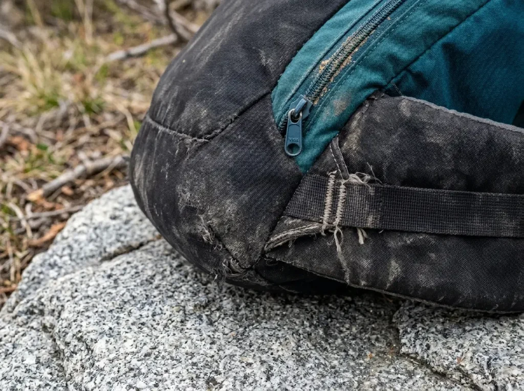 Close-up of a backpacking backpack hipbelt stitching and abraded bottom panel wear points