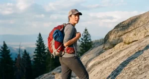 Best Hiking Daypacks for the Hike You Actually Do Hiker pausing on a granite trail wearing a 22-liter Osprey daypack at golden hour