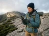 Which Hiking Navigation Devices You Actually Need Hiker checking a handheld GPS on a granite ridge, comparing hiking navigation devices on the trail