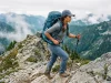 Best Women’s Backpacking Packs for Your Torso Woman hiking a granite ridge with a loaded Osprey Aura AG 65 women's backpacking pack