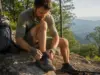 Best Trail Runners for Thru-Hiking That Go the Distance Thru-hiker lacing HOKA Speedgoat 6 trail runners on an Appalachian Trail ridge at sunrise