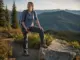 Best Women’s Hiking Shoes That Fit a Woman’s Foot Woman on a switchback in women's hiking shoes, dust on the leather uppers, ridgelines behind her