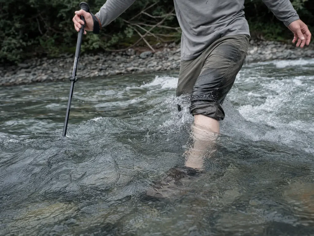 Low-cut hiking shoes fully submerged during a deep mountain creek crossin