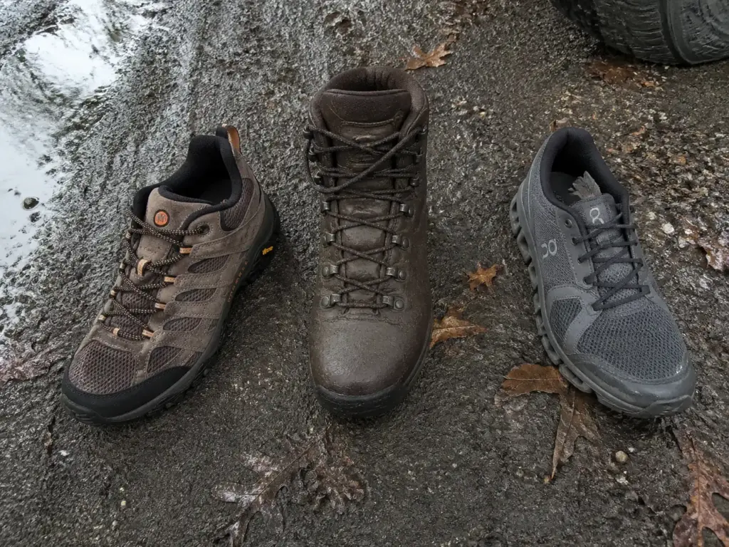 Three footwear types lined up on wet ground showing collar height differences for wet trail hiking