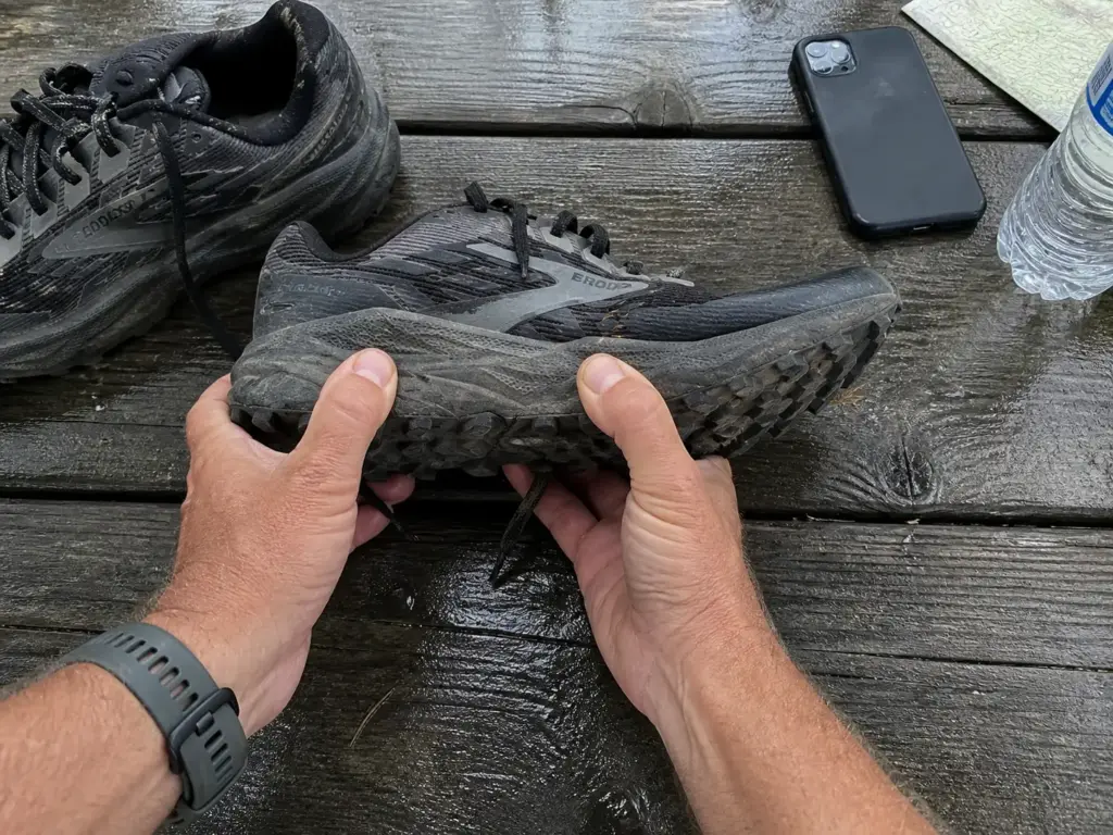 A worn trail runner outsole checked for tread wear after hundreds of backpacking miles