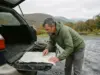 Best Hikes in New York Sorted by Range and Effort Hiker checking a paper map at a Catskills trailhead in New York before choosing a route