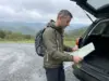 11 Best Hikes in North Carolina Blue Ridge Country Hiker checking a paper map at a Blue Ridge Parkway trailhead in North Carolina on an overcast fall morning