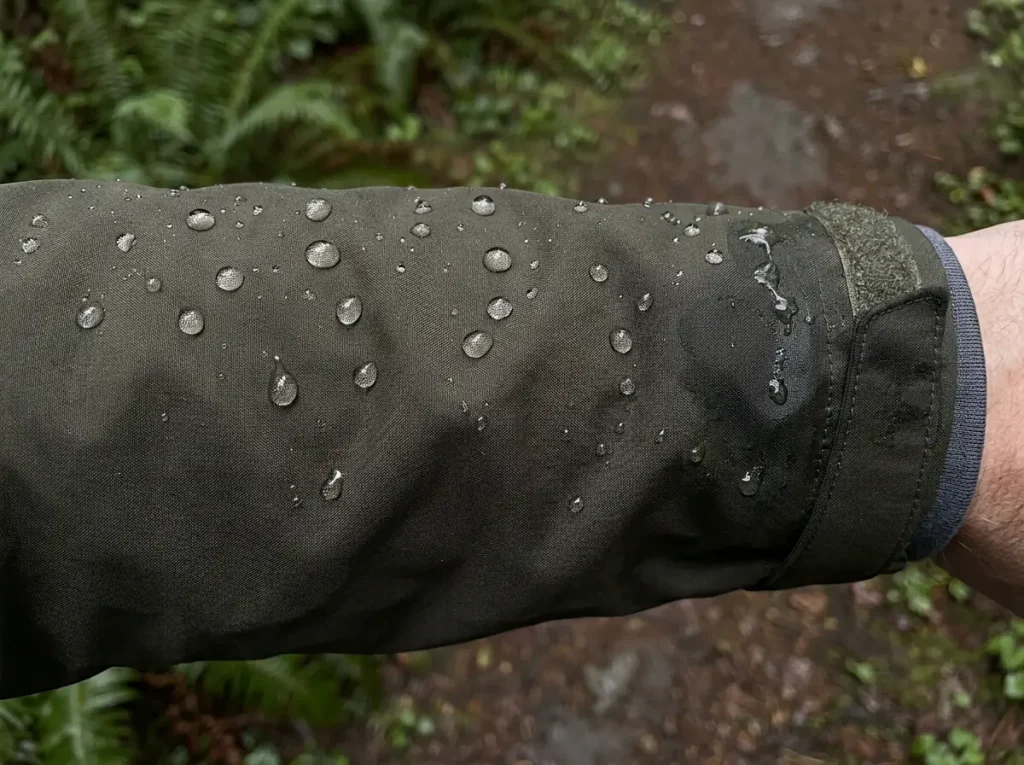 Water beading on a waterproof rain jacket sleeve showing an intact DWR finish