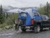 Truck Bed Tent Buying Guide Measure Your Bed First Man sitting on a pickup tailgate with a Napier Sportz truck bed tent pitched over the bed on a cool morning