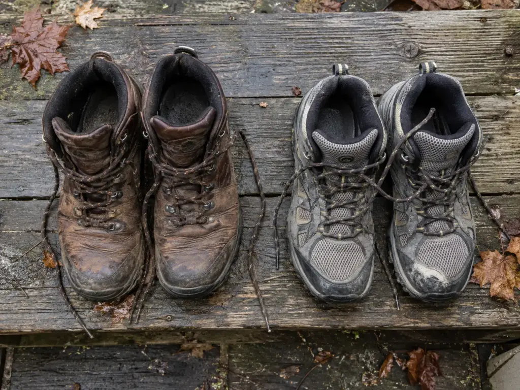 Leather and synthetic hiking boots side by side on a porch step to show how the two materials differ