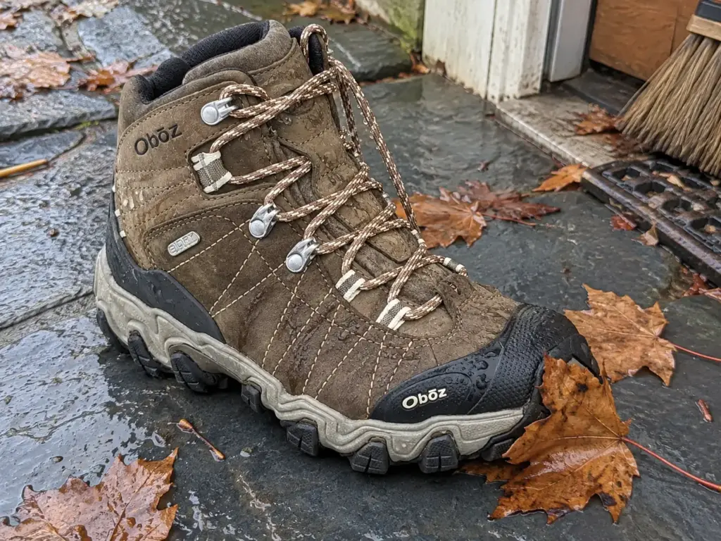 Oboz Bridger Mid B-DRY women's hiking boot with water beading on the upper on a wet slate back step after rain