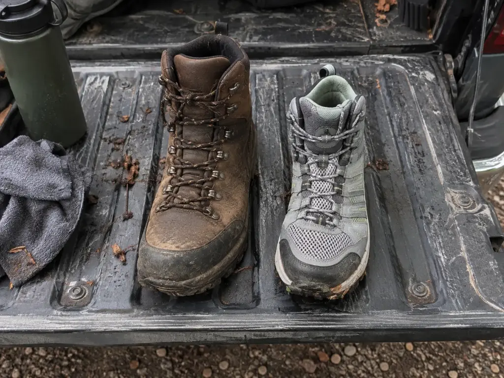 One heavy leather hiking boot beside one light fabric hiking boot on a pickup tailgate to compare old and new lines