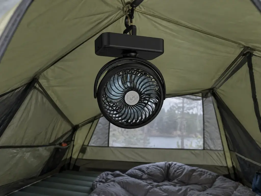 Battery tent fan hanging from the ceiling loop inside a pitched tent to move air on still, humid nights